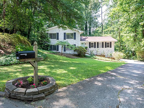 Street view of house and large wooded lot.