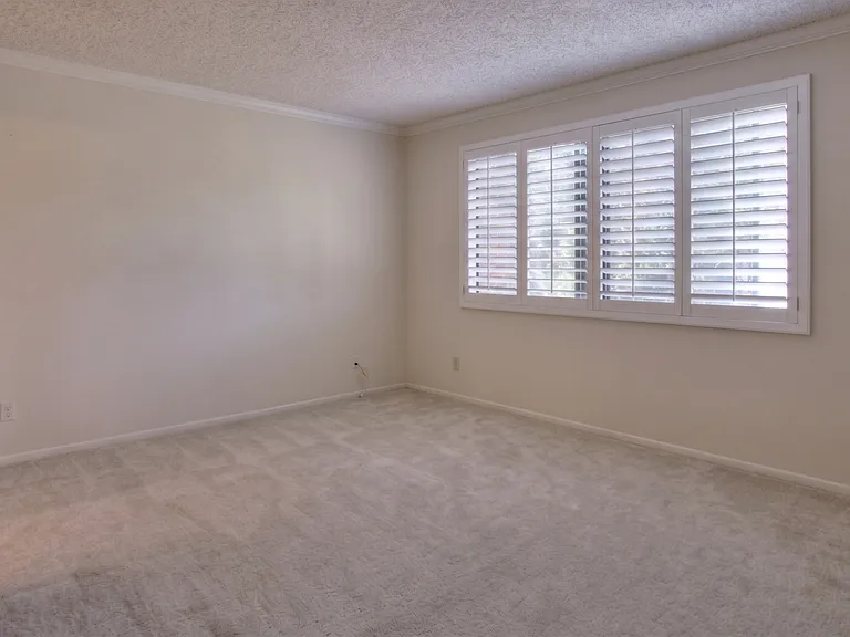Primary Bedroom with carpet and wood shutters. Picture from previous listing