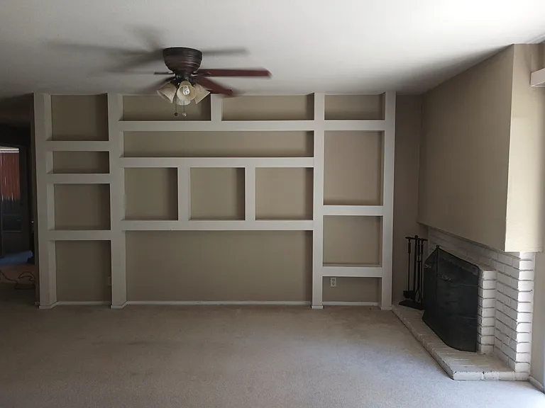 Family Room with build-in shelving off the kitchen with fireplace and fireplace tools and screen