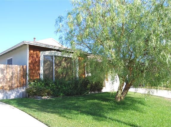 Front of home with large shade tree in front yard