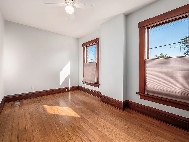 Bedroom 2 with south facing windows. Ceiling fan/lighting has been replaced since photos. Bamboo floors and up/down cellular blinds.