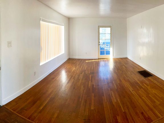 Living room from kitchen. Main entrance to house on the left, side entrance leading to backyard in center.