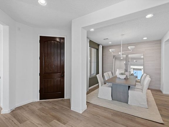Foyer features beautiful wood-like flooring and interior archways leading to a formal dining room.