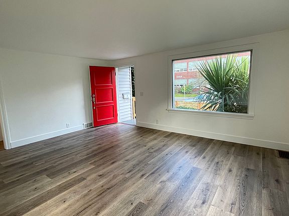 Main level living room features laminte flooring and large picture window