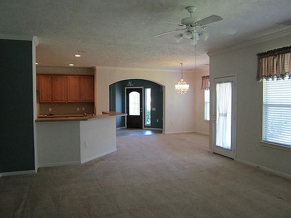 Large family room with fans, windows & french door to patio.