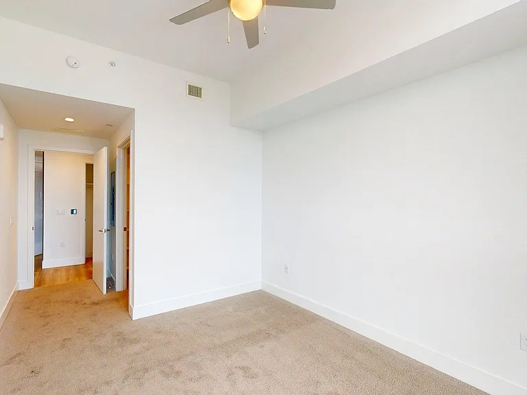 Spacious apartment Bedroom with carpet.