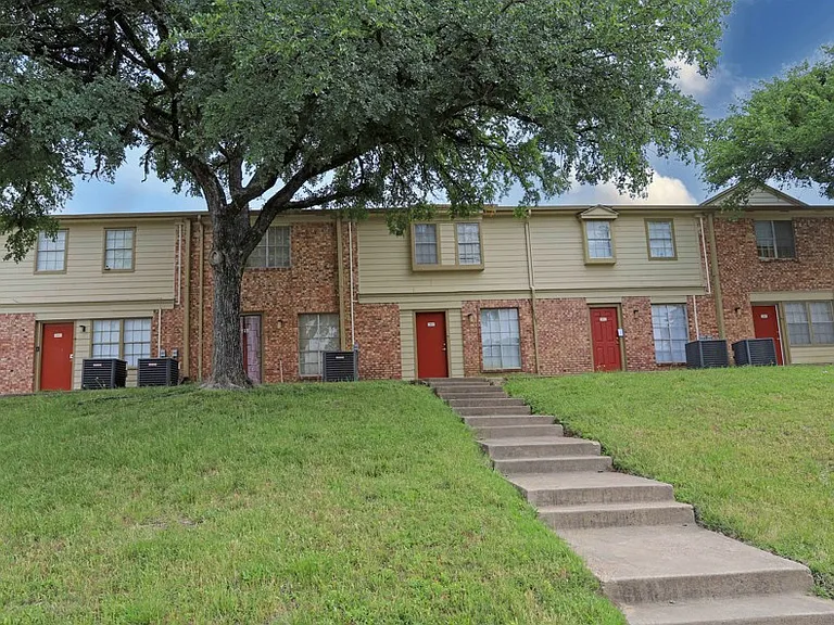 Beautifully maintained two-story brick buildings with tree-lined walkways and charming curb appeal.