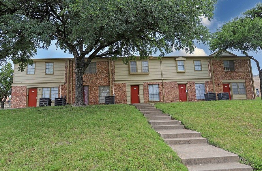 Beautifully maintained two-story brick buildings with tree-lined walkways and charming curb appeal.