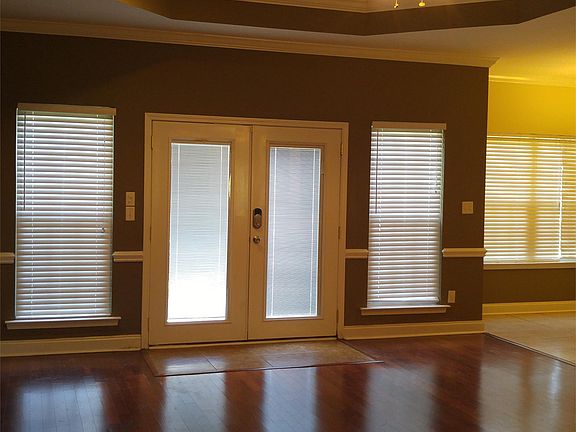 Large living room with tray ceiling and double doors to the deck and back yard