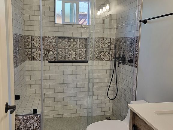 Newly installed bathroom with new tiles, toilet, fixtures, vanity and shower.