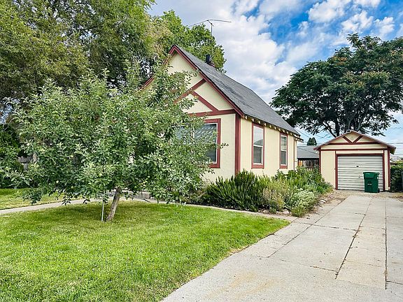 Front of home with apples on the tree, an herb garden and lilac bushes!