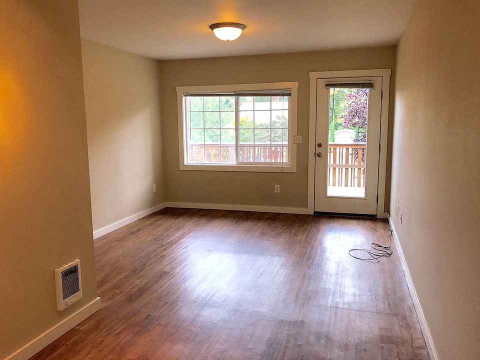 Living area with wood floors and front door access.
