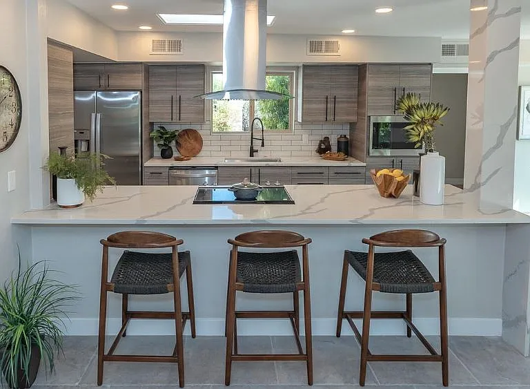 quartz counters with cooktop and serving bar. open to living space
