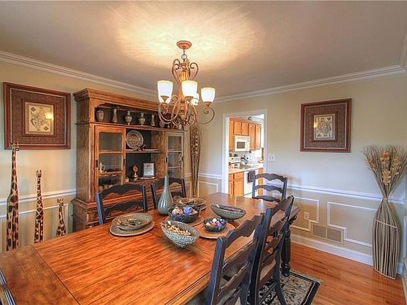 Formal Dining Room features custom trim, chair rail and crown molding and hardwood floors.