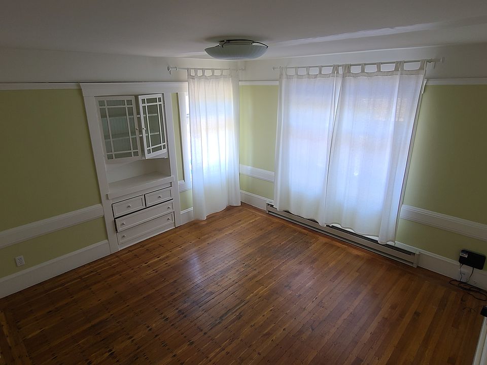 living room with built in cabinetry and large new windows that over look the back yard and wood floors