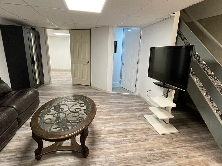 basement living room with leather recliners, TV included