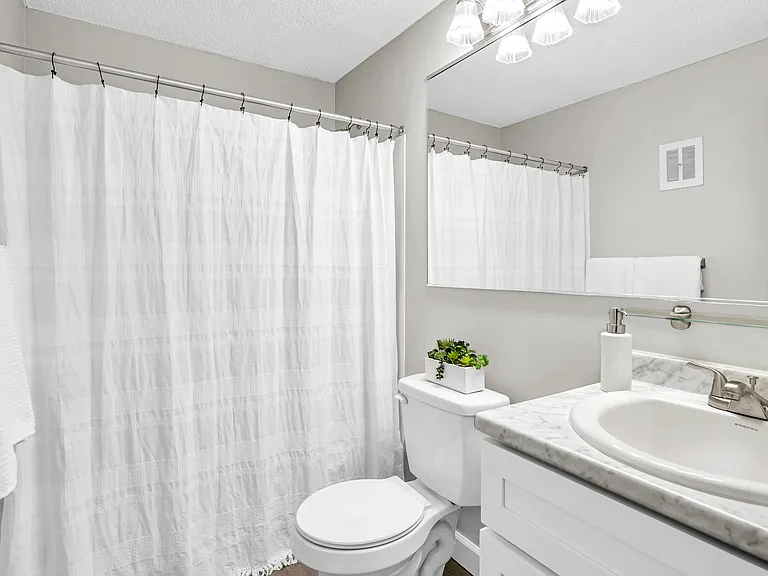 Step into elegant bathrooms featuring wood-style floors and marble-style countertops.