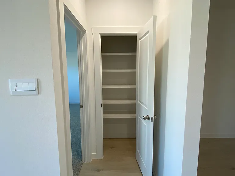 Storage closet by master bedroom (left door)