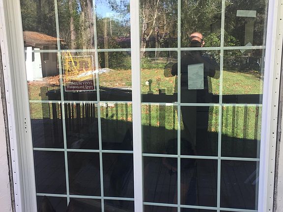 Bad sliding door onto deck, storage shed seen in reflection (dog not included!)