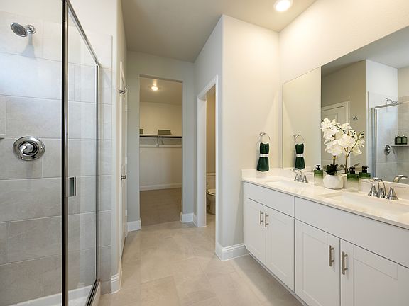 Primary bathroom with double vanity and large walk-in closet