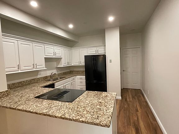 View of kitchen area from dining room Contemporary lighting above
