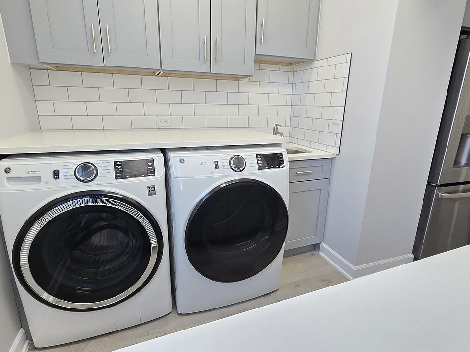 Super convenient in-unit laundry room with cabinets and wash sink, hard to find feature!