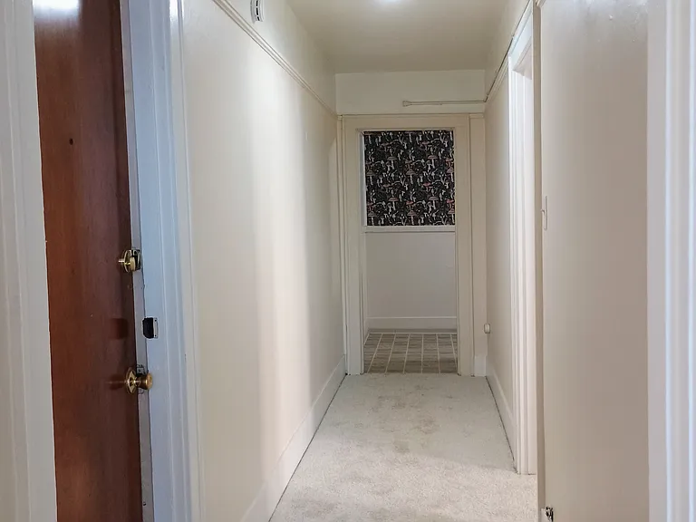 Hallway view from the living room. Kitchen located at the end of the hall.