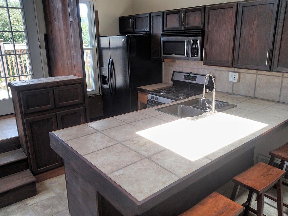 View of kitchen w side by side refrigerator-ice water in door,gas cook stove ,microwave over stove,dishwasher & double bowl sink