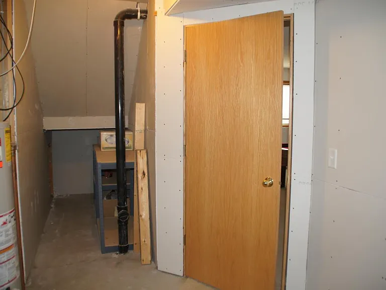 Laundry/mechanical area with extra storage available under the steps