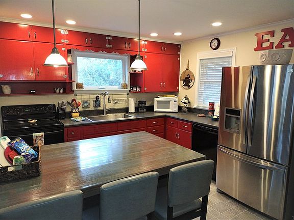 Fully stocked kitchen with new fridge, dishwasher, microwave, and toaster and seating for 5
