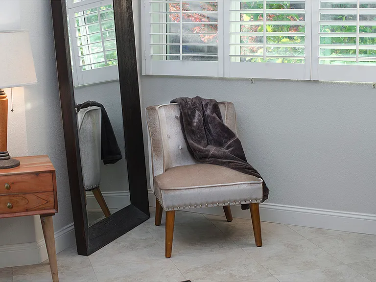 Primary bedroom tall dressing mirror and chair detail.