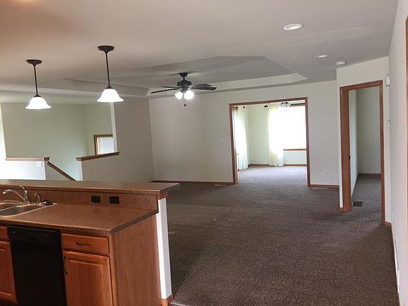View from standing in the Foyer and looking through the living room to the sunroom and the staircase going downstairs