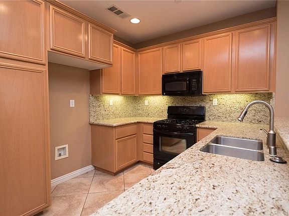 Granite countertops and plenty of cabinet space. A black refrigerator is also included in rental but not shown in this picture.