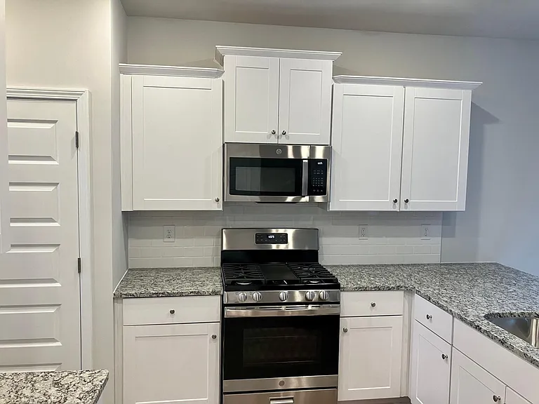 Kitchen with gas stove, microwave, dishwasher, refrigerator, eat in bar area
