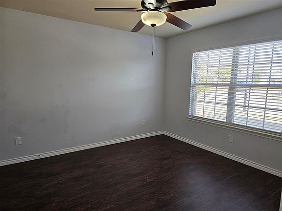 Spare room with ceiling fan and dark hardwood / wood-style flooring