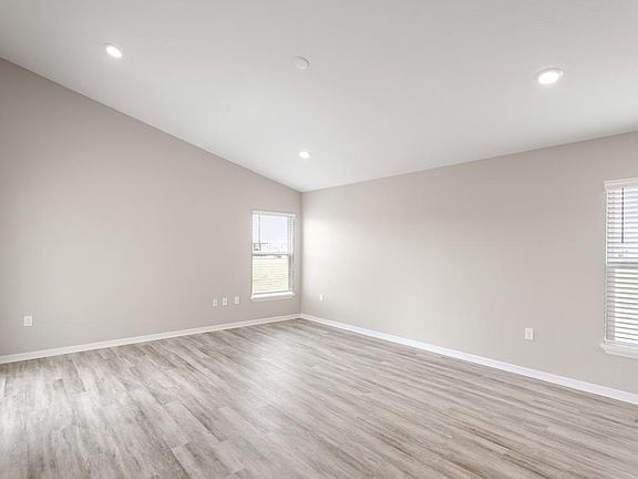 Enjoy a welcoming, open-concept living area with airy volume ceilings - Aurora by Highland Homes