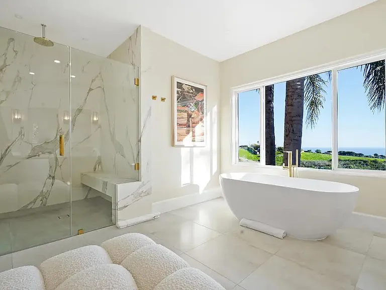 Relax in the spa-style master bathroom with a deep soaking tub and ocean vista.