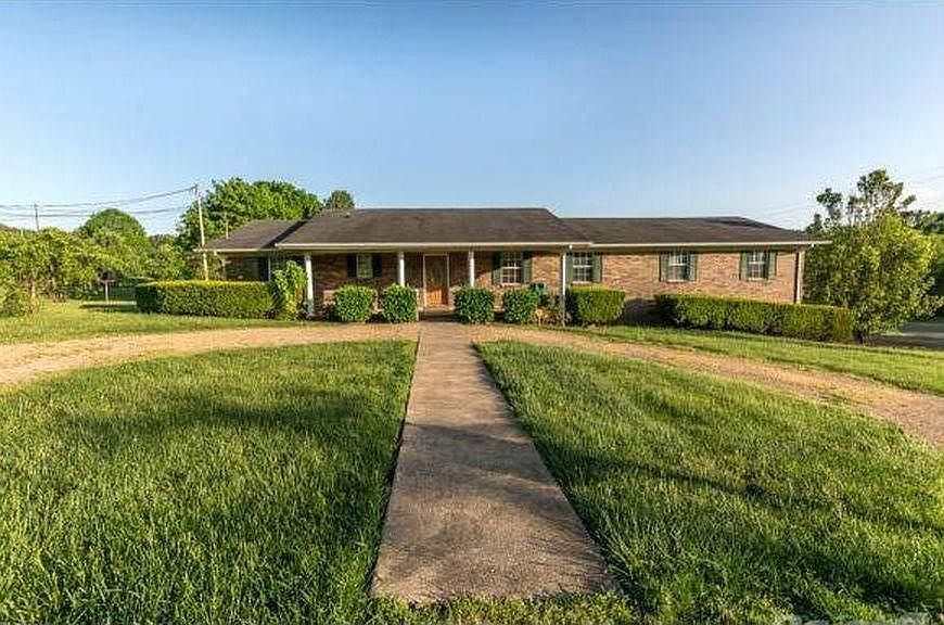 Front view with center sidewalk and half-circle pebble stone driveway.