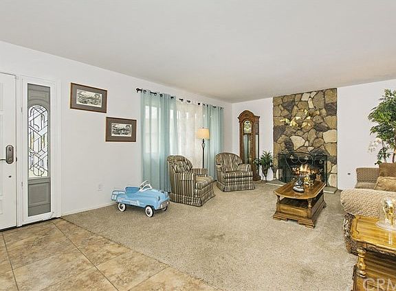 Notice the wing window to the right of the front door. Rock fireplace in a spacious living room.