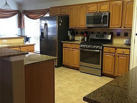 VIEW OF LARGE ISLAND KITHCHEN WITH GRANITE AND UPDATED APPLIANCES