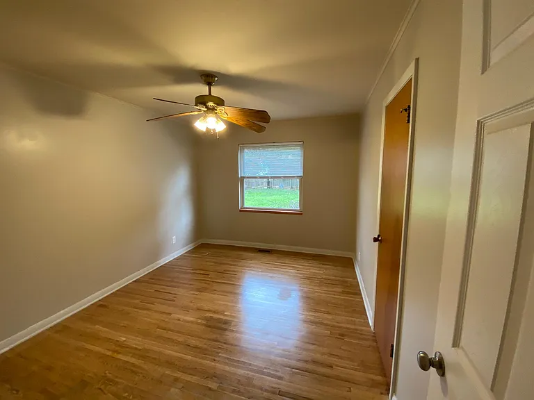 1st bedroom with closet, shades, and fan
