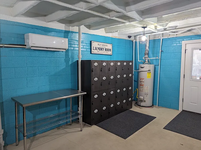 Indoor laundry area with convenient on site lockers, adding extra functionality and everyday ease for residents.