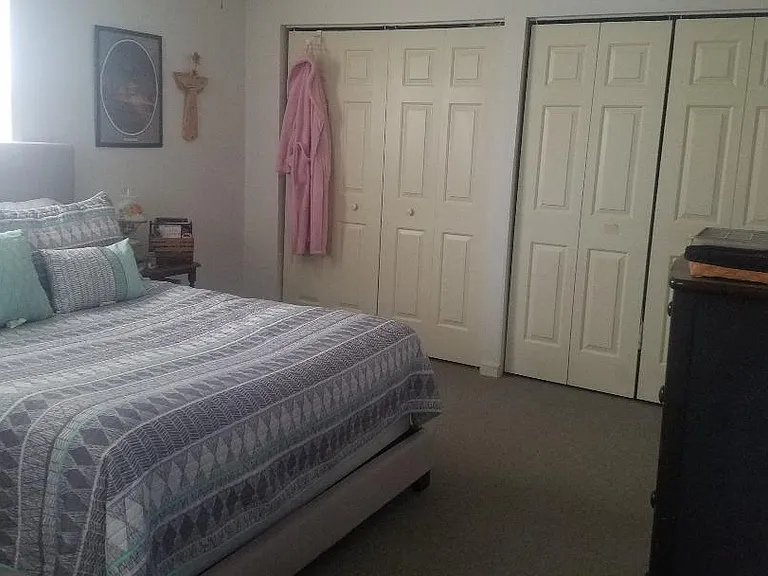 Large master bedroom with one full wall of closets