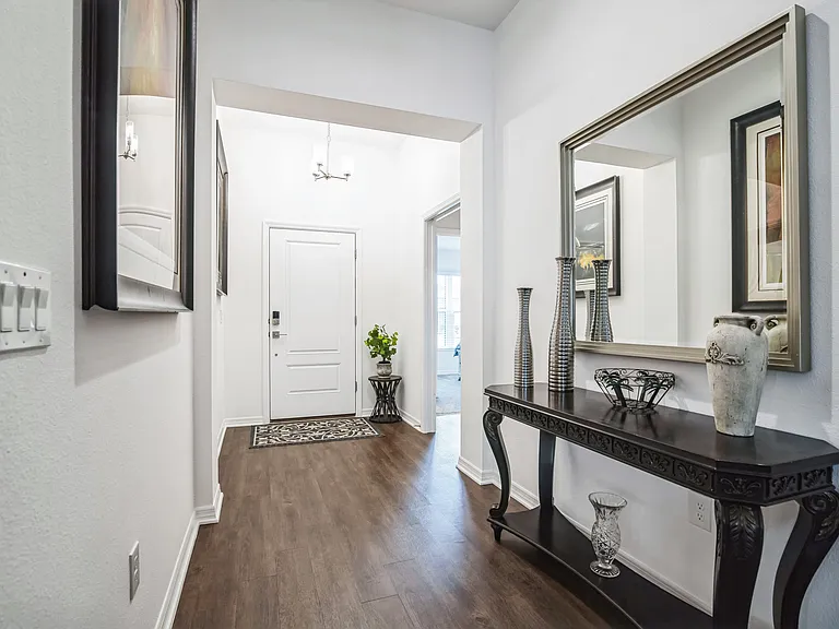 The Main Entry Hallway to the House to the Front Door, the Side Hallway access to Primary and Secondary Bedrooms, with a Shared Bath.