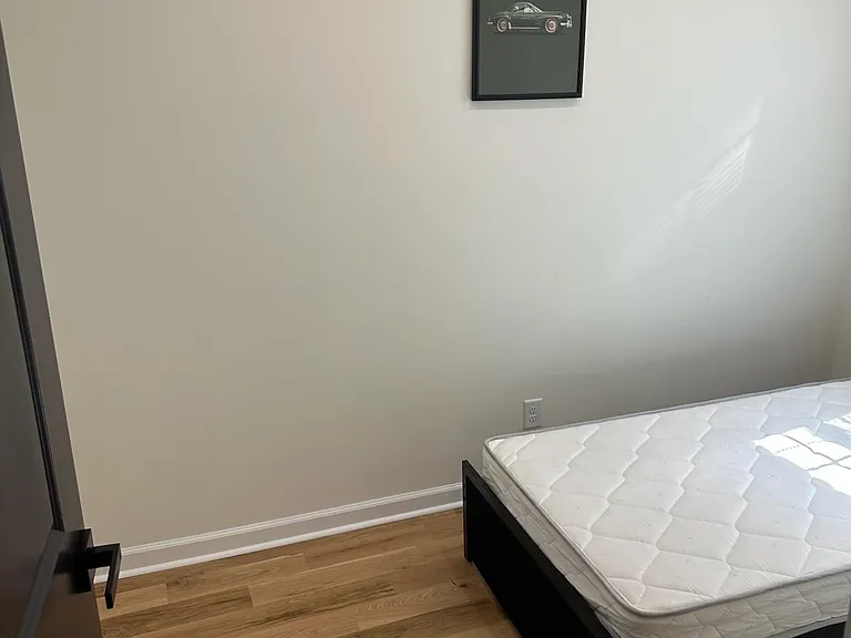 Private bedroom with wood-look flooring and space for a full bed and side table, plus a closet for everyday storage.