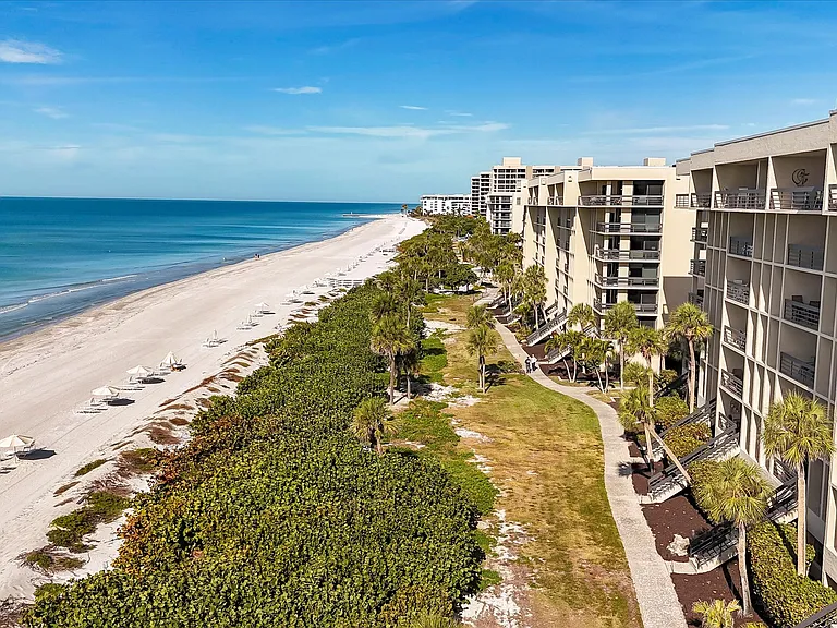 View of building 9 and proximity to beach with walkways behind building with direct access to pool and beach