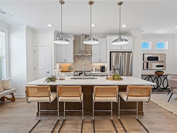 Kitchen featuring stainless steel fridge with ice dispenser, wall chimney range hood, ornamental mol