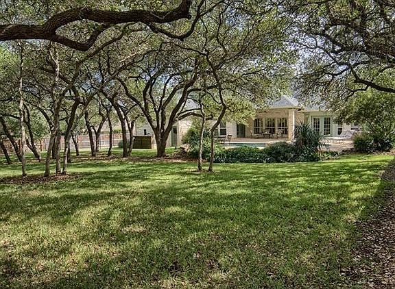 The spacious, heavily treed backyard offers TONS of potential!