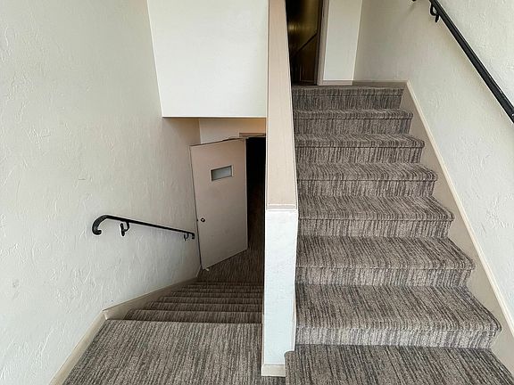 Explore the sleek design of this apartment's staircase, offering seamless access to upper levels.