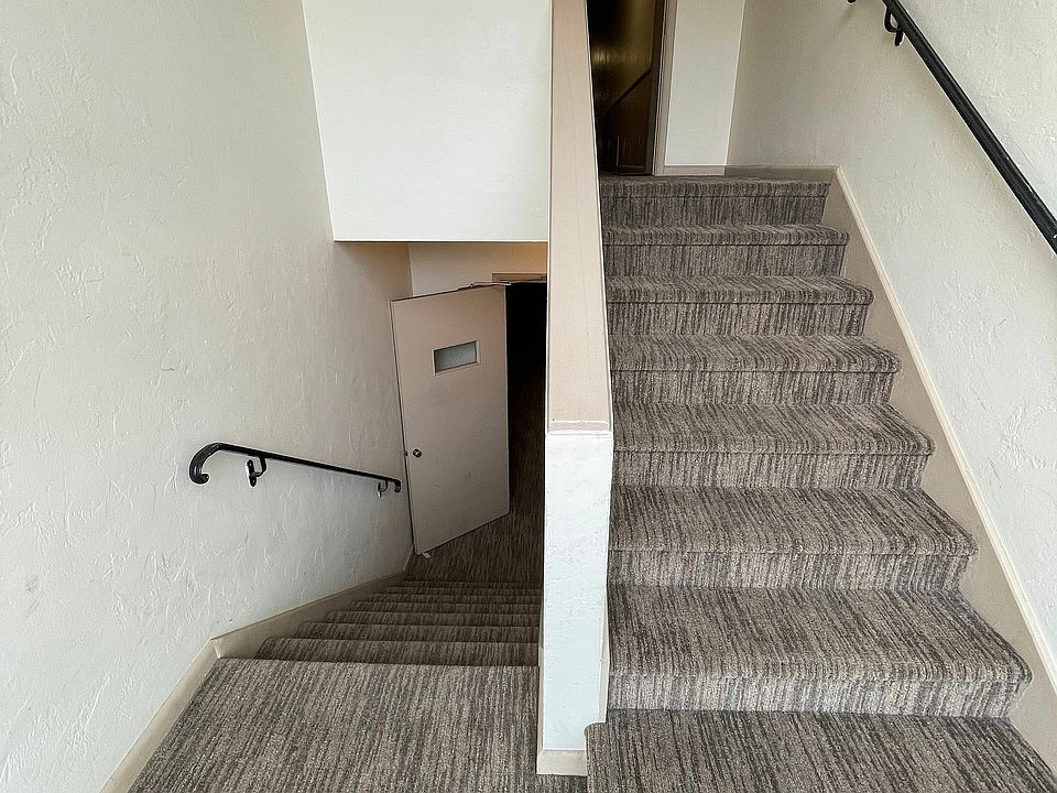 Explore the sleek design of this apartment's staircase, offering seamless access to upper levels.